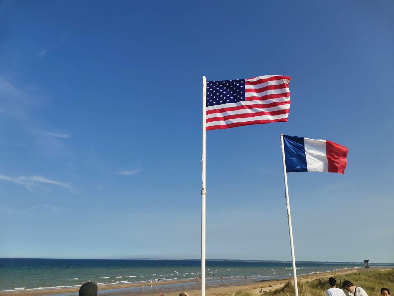 The American and French flags above the dunes.