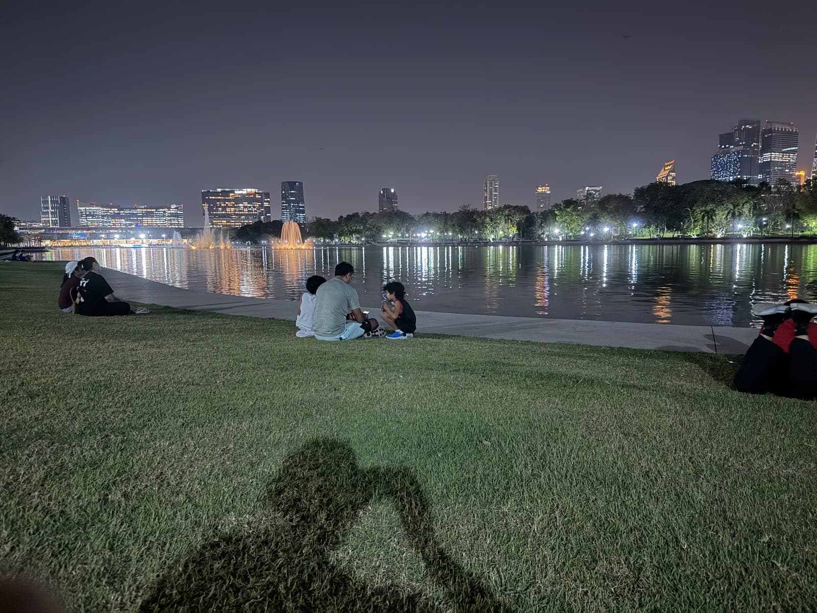 7:21 pm. Night on the lawn, the fountains lit across the water.