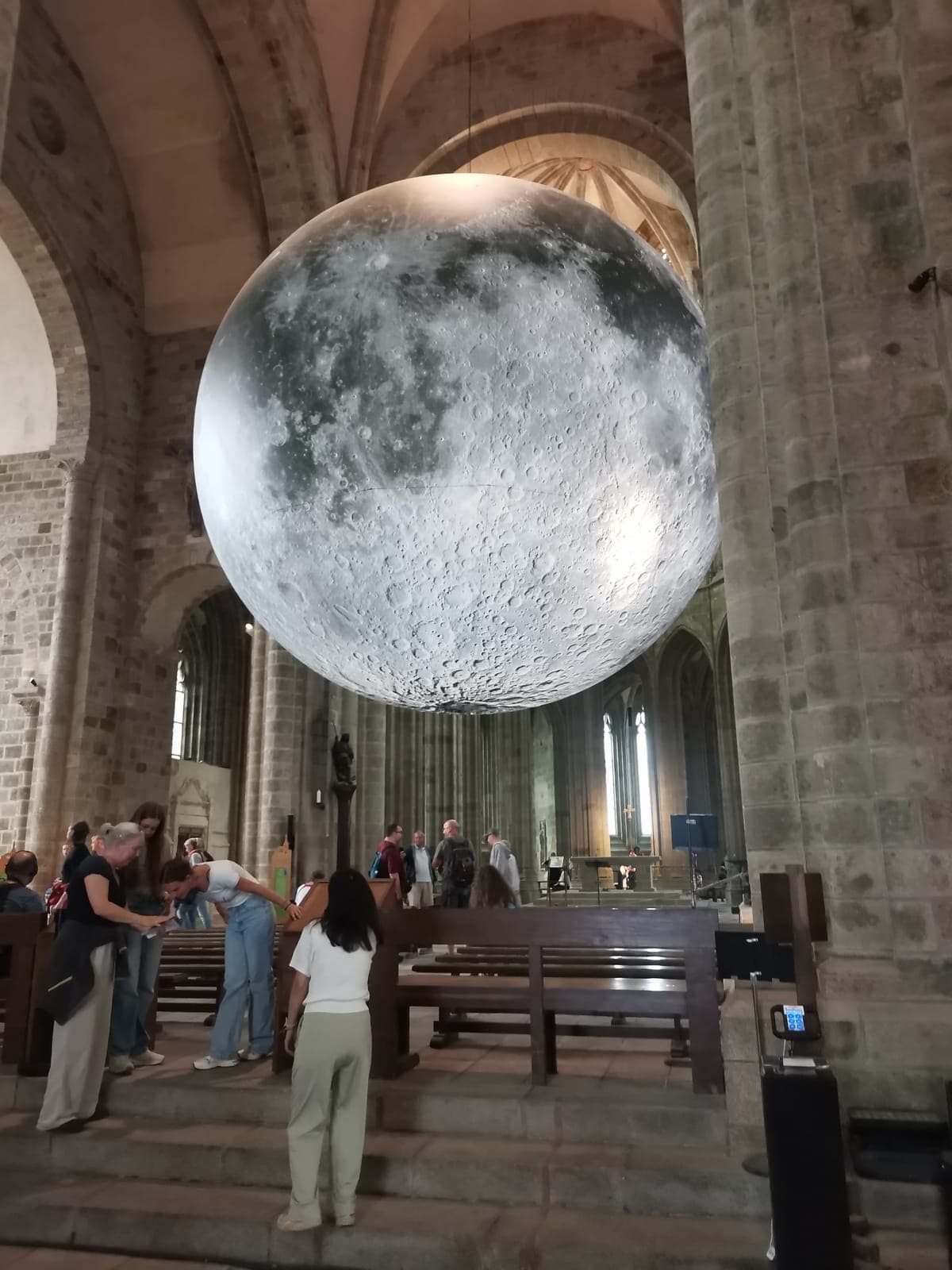 The village below the abbey, then a giant moon inside it.